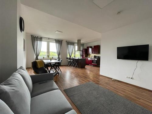 uma sala de estar com um sofá e uma televisão na parede em Ruhrpott Apartment Zentral em Herne