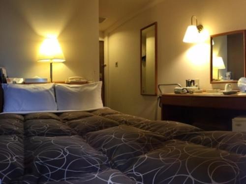a large bed in a hotel room with a desk at Az Inn Fukui - Vacation STAY 65940v in Fukui