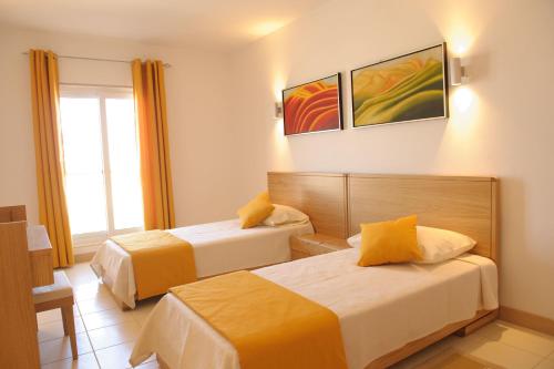 a hotel room with two beds and a window at Agua Hotels Sal Vila Verde in Santa Maria