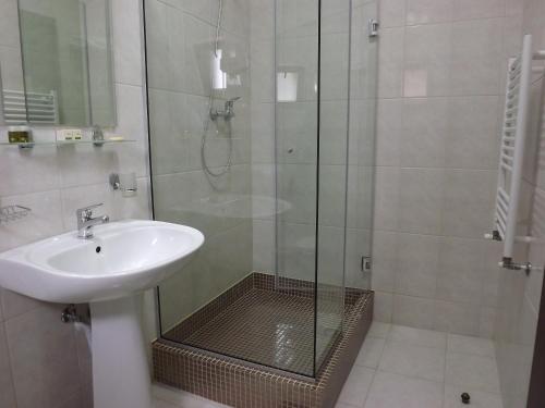 a bathroom with a sink and a shower at Hotel Magnus Galati in Galaţi