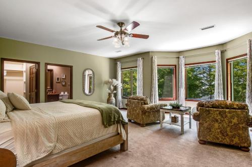 - une chambre avec un lit, deux chaises et un ventilateur de plafond dans l'établissement Forever Shores, à Arkdale
