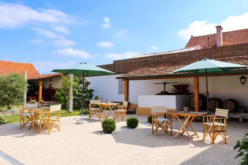 a patio with tables and chairs and umbrellas at Casa D'Oliveira in Aveiro
