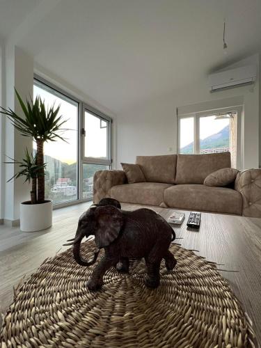 a baby elephant standing on a rug in a living room at Relax Apartmani in Sutomore