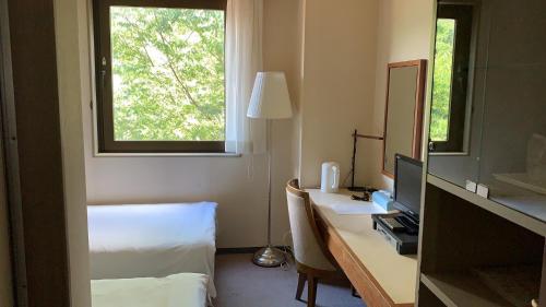 um quarto de hotel com uma secretária, uma cama e uma janela em Hotel Fuyokaku - Vacation STAY 13411v em Fujiyoshida