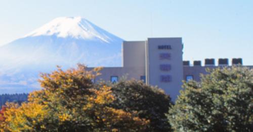 uma montanha à distância com um edifício e árvores em Hotel Fuyokaku - Vacation STAY 13411v em Fujiyoshida