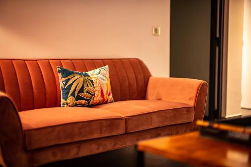 a brown couch with a colorful pillow on it at Secret Pearls by Matira Beach in Bora Bora