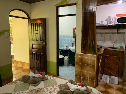 Baño con toallas en el suelo frente a un espejo en Cabinas Tito en Cahuita