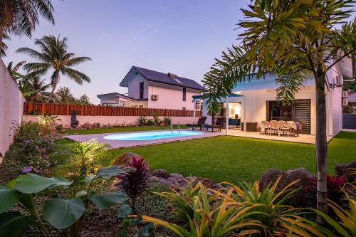a backyard with a swimming pool and a house at Hidden Mo'a Villa in Bora Bora