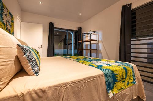 a bedroom with a bed with a colorful blanket at Secret Pearls by Matira Beach in Bora Bora