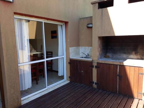 a balcony with a sliding glass door to a kitchen at Arena y Sol - casas de playa in Mar Azul