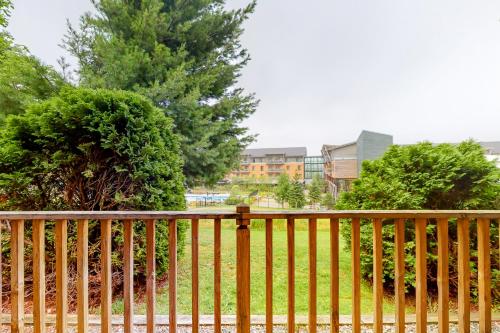 a wooden fence in front of a yard with trees at Slopeside 705 in Jay