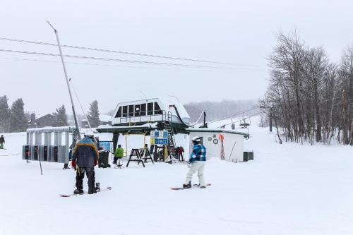 two people on skis in the snow next to a ski lift at Slopeside 705 in Jay
