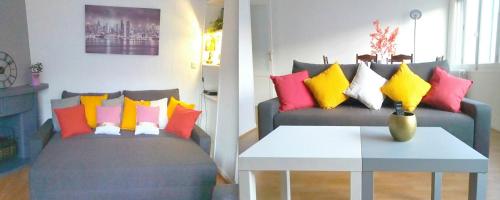 - un salon avec un canapé et des oreillers colorés dans l'établissement Séjour Perpignan à 20 minutes de l'Espagne avec petit-déjeuner à la demande à Les Lumineuses du Palais des Rois de Majorque, à Perpignan