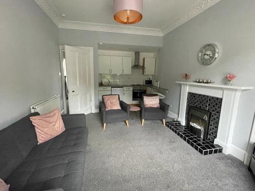 a living room with a couch and a fireplace at Our Wee Getaway in Rothesay