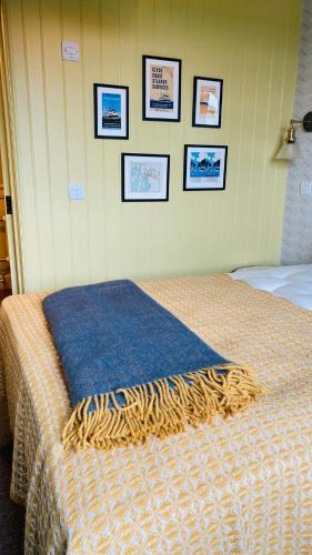 a bed in a bedroom with pictures on the wall at Custom House Hotel in Bowling