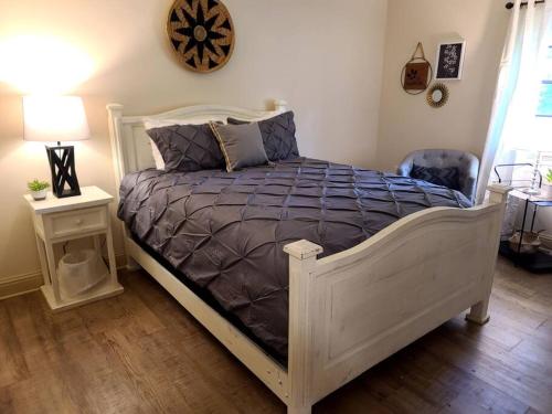 a bedroom with a white bed with a purple comforter at Judy House in Hammond