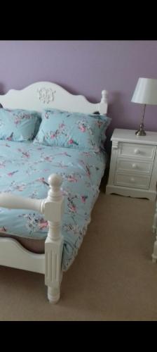 a bedroom with a white bed and a white night stand at Mels accomodation in Letterkenny