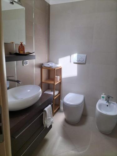 a bathroom with a white sink and a toilet at Casa vacanza HADA in San Giacomo degli Schiavoni