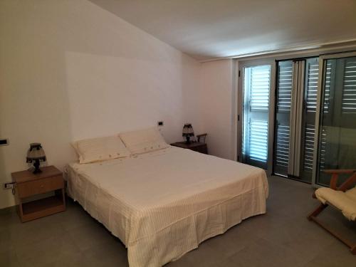 a bedroom with a bed and a large window at Casa vacanza HADA in San Giacomo degli Schiavoni