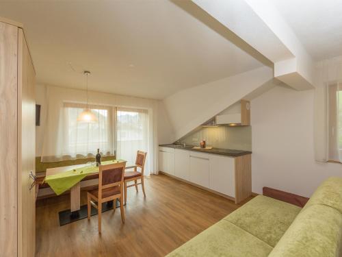 a kitchen and dining room with a table and chairs at Garni Appartement Alpenresidence in Cadipietra