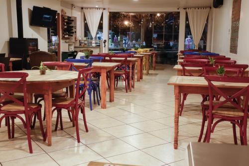 a row of tables and chairs in a restaurant at Rodeio Hotel in Rodeio Bonito