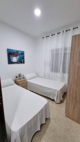 twee bedden in een kamer met witte muren bij APARTAMENTO ECONOMICO Y CENTRICO in Castellón de la Plana