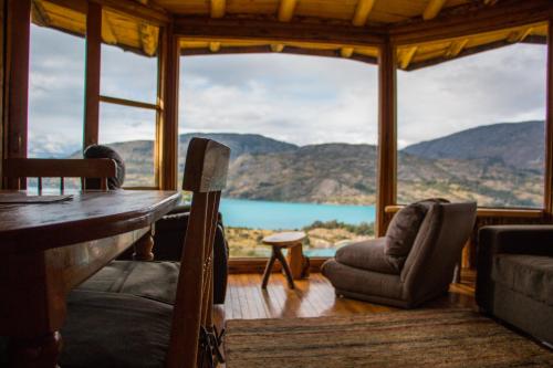 a room with a table and chairs and a large window at Mallin Colorado Ecolodge in Aldana
