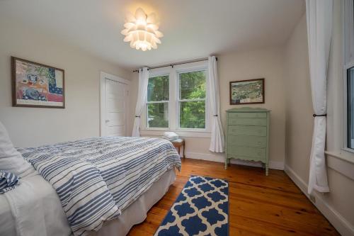 1 dormitorio con cama, ventana y lámpara de araña en Hilltop Hideaway, en Brevard
