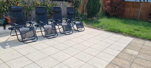 a group of chairs sitting on a patio at Modern 3 bedroom house, 3 Bathroom, secure parking, Wi-Fi & Garden in Leeds