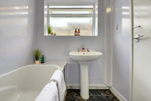 a bathroom with a sink and a bath tub and a sink at Cheerful 2 Bedroom Home, Sleeps 5 Guest Comfy, 1x Double Bed, 3x Single Beds, Free Parking, Free WiFi, Suitable For Business, Leisure Guest,Coventry, Midlands in Coventry