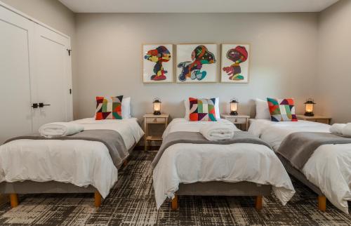 a room with four beds with pillows on them at Mountain to Sea Modern in Asheville