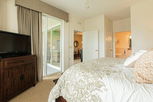 a bedroom with a bed and a flat screen tv at Greenlinks-Lely-Building 1200 in Lely Resort