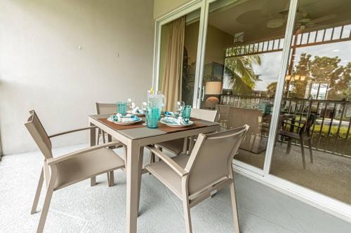 a dining table and chairs on a porch with a view at Greenlinks-Lely-Building 1200 in Lely Resort
