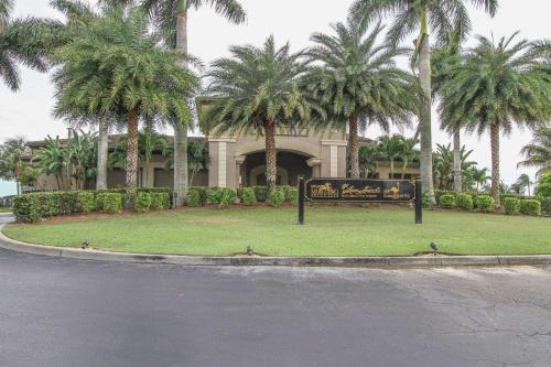 a sign in front of a building with palm trees at Greenlinks-Lely-Building 1200 in Lely Resort