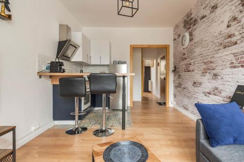 un salon avec un canapé et un mur de briques dans l'établissement Centre Ville LH - Parking Privé - Évasion Urbaine, au Havre