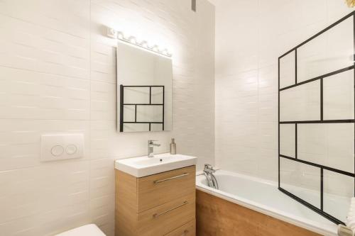 une salle de bain blanche avec un lavabo et une baignoire dans l'établissement Centre Ville LH - Parking Privé - Évasion Urbaine, au Havre