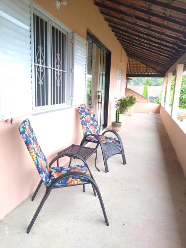 two chairs sitting on the porch of a house at Casa com piscina com linda vista panorâmica in Araruama