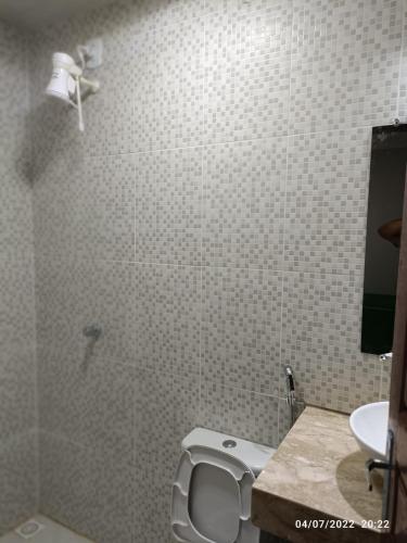 a white bathroom with a toilet and a sink at Pousada Recanto Beach in Camocim