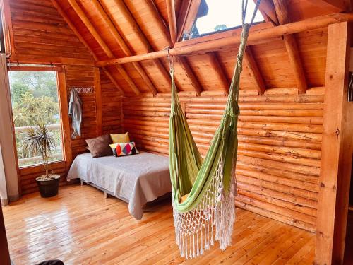 una habitación con una hamaca en una cabaña de madera en BRUMA BLANCA CHALETS, en Medellín