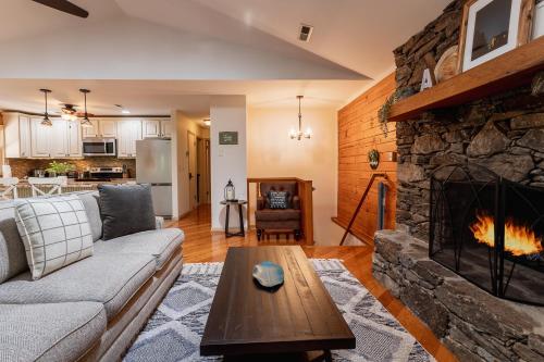 sala de estar con sofá y chimenea en Skyridge Cabin, en Fletcher