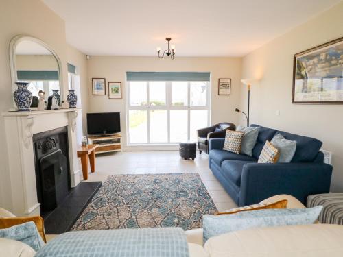 a living room with a blue couch and a fireplace at Stillwaters in Bushmills
