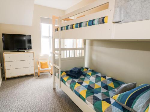 a bedroom with a bunk bed and a tv at Stillwaters in Bushmills