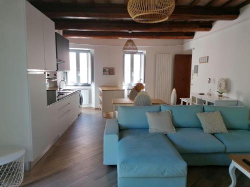 a living room with a blue couch and a kitchen at Residenza il Duomo in Nocera Umbra