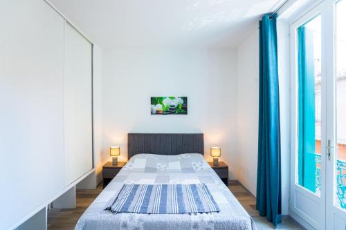 a small bedroom with a bed and a window at Appartement Les Halles , Climatisation, Terrasse, Garage in Narbonne