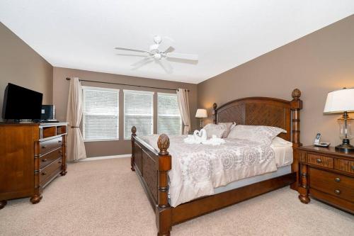 een slaapkamer met een bed en een plafondventilator bij Pool, Disney, Fast Wi-Fi - World Class 3-bed Home in Kissimmee