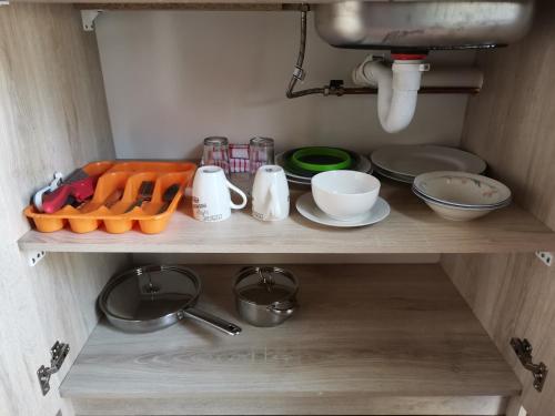 a kitchen shelf with dishes and utensils on it at Dreamers nest in Richards Bay