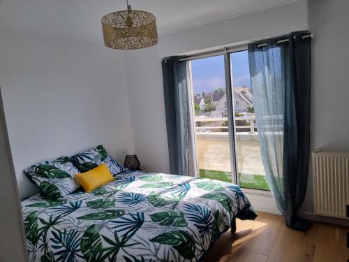a bedroom with a bed and a large window at Lion Beach in Lion-sur-Mer