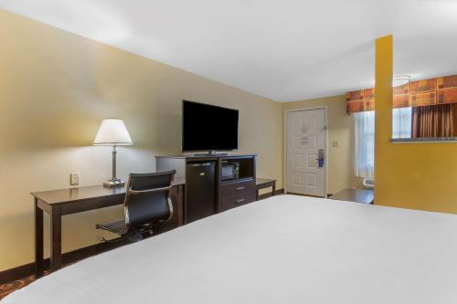 a hotel room with a bed and a desk and a television at Best Western Benton Inn in Benton