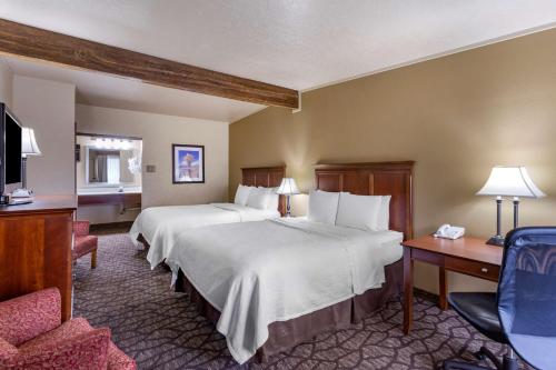 een hotelkamer met 2 bedden en een bureau bij Best Western Dunmar Inn in Evanston