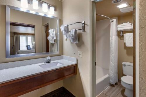 een badkamer met een wastafel, een toilet en een spiegel bij Best Western Dunmar Inn in Evanston